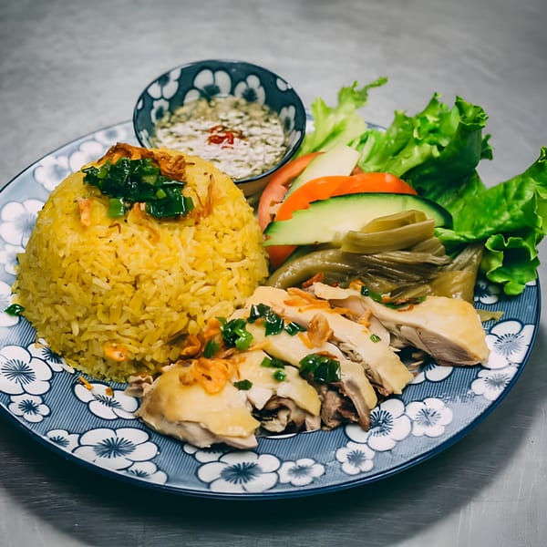 Hên Vietnamese Restaurant's chicken rice dish with yellow rice, sliced chicken, and a side salad.