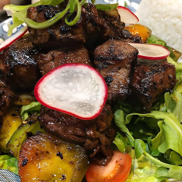 Close-up of Hên Vietnamese Restaurant's shaking beef with bell peppers, radishes, and greens.